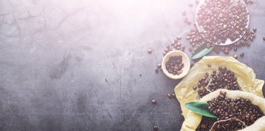 Bir poşet kahve. Kahve çekirdekleri masada kavrulmuş. Pişirmek için yapraklı kahve çekirdekleri.