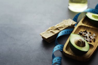 Avokado yemek tarifleri. Tahta kesme tahtasında servis edilen olgun yeşil avokado..