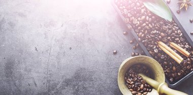 Bir poşet kahve. Kahve çekirdekleri masada kavrulmuş. Pişirmek için yapraklı kahve çekirdekleri.