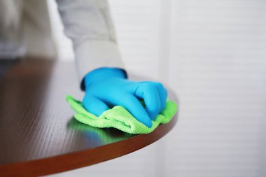 Ev temizliği konsepti. Yüzeylerin tozunu sil. Dezenfektan kapısı TV elektriğini kontrol ediyor. Evdeki karantinada hijyenik tedavi.