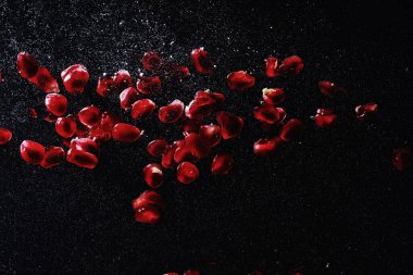 Olgun tatlı nar tohumlarına su damlaları düşer. Metnin için kopyalama alanı olan taze nar arkaplanı. Vejetaryen ve vejetaryen kavramı.