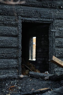 Yangından sonra ahşap ev. Kütüklerdeki kömürleri. Evin külleri yangından. Yanmış kır evi..