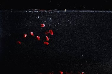 Olgun tatlı nar tohumlarına su damlaları düşer. Metnin için kopyalama alanı olan taze nar arkaplanı. Vejetaryen ve vejetaryen kavramı.