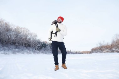 Bir adam sırt çantasıyla seyahat eder. Ormanda kış yürüyüşü. Kışın parkta yürüyüş yapan bir turist..