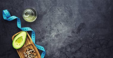 Avokado yemek tarifleri. Tahta kesme tahtasında servis edilen olgun yeşil avokado..