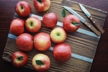 Tahtadaki taze elmalar. Kırmızı elma hasadı. Masada meyve ve tarçın var..