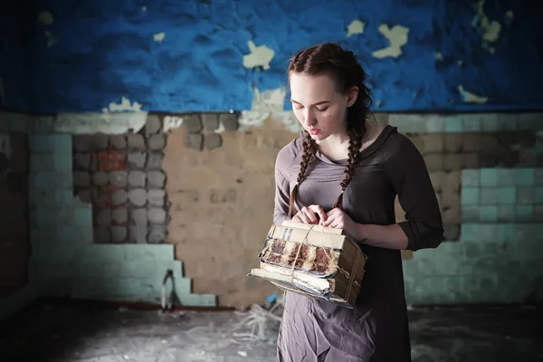 A young girl with old books in the old house