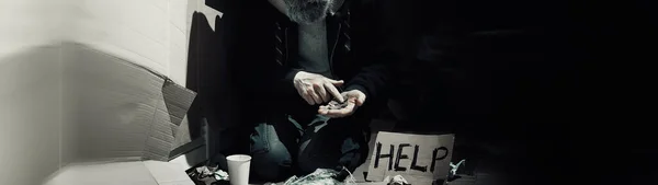 一个无家可归的留胡子男子坐在街上的箱子上寻求帮助 无家可归的人需要钱去买食物和过夜 — 图库照片
