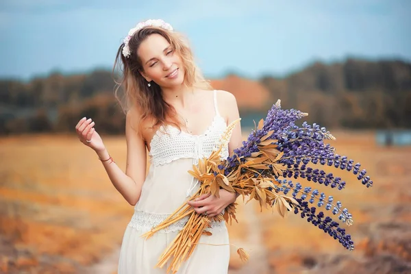 秋には自然の上に青い花の花束を持つ美しい女の子 — ストック写真