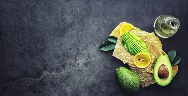 Avokado yemek tarifleri. Tahta kesme tahtasında servis edilen olgun yeşil avokado..