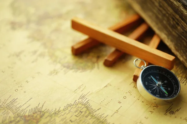 Travel and adventure search concept. Vintage aged map with shabby book and compass. Shabby book and compass on the table.