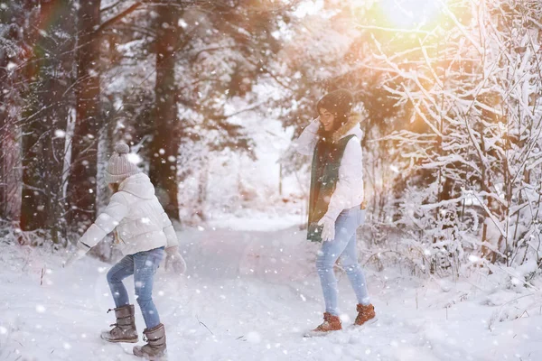 年轻的家庭散步 妈妈和女儿在雪地的公园里散步 — 图库照片