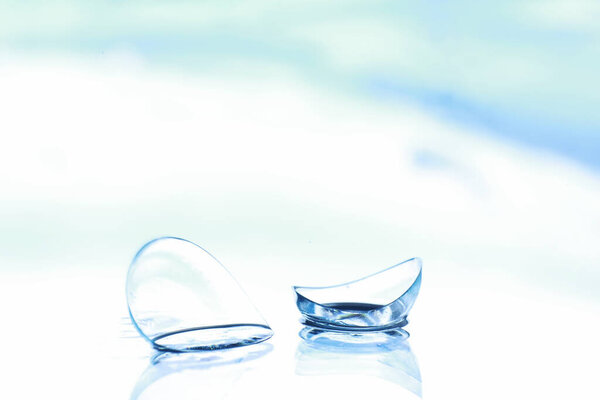 Tools for vision correction. Glasses and lenses with diopters on background of splashes and blurry.