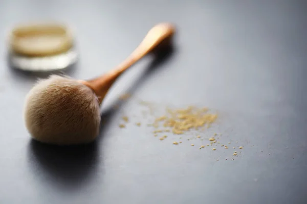 Powder and makeup brush. Brown powder on background. Makeup products. Style concept.