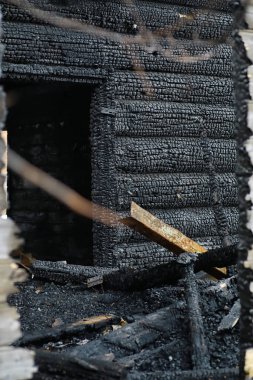 Yangından sonra ahşap ev. Kütüklerdeki kömürleri. Evin külleri yangından. Yanmış kır evi..