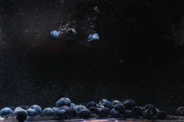 Olgun tatlı yaban mersinine su damlası. Metnin için fotokopi alanı olan taze yabanmersini arkaplanı. Vejetaryen ve vejetaryen kavramı. Yabanmersini dokusunun makro dokusu.