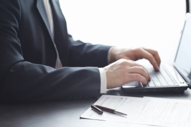 Müdür ofisteki bir dizüstü bilgisayarda çalışıyor. İşadamı çevrimiçi işlem yapıyor. Değiş tokuş internet üzerinden yapılıyor..