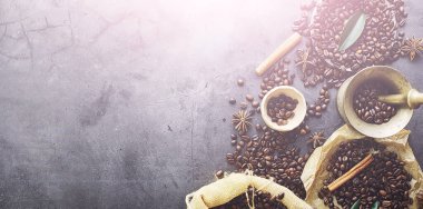 Bir poşet kahve. Kahve çekirdekleri masada kavrulmuş. Pişirmek için yapraklı kahve çekirdekleri.