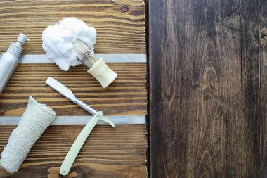 Ahşap dokuda tıraş aksesuarları. Aletler. Tek kullanımlık tıraş makinesi, fırça, köpük tehlikeli tıraş makinesi..