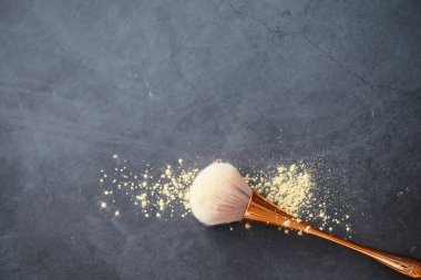 Toz ve makyaj fırçası. Arka planda kahverengi toz. Makyaj ürünleri. Biçim konsepti.