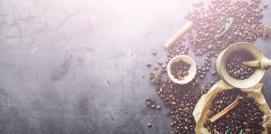 Bir poşet kahve. Kahve çekirdekleri masada kavrulmuş. Pişirmek için yapraklı kahve çekirdekleri.