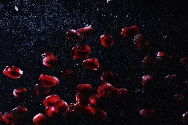 Olgun tatlı nar tohumlarına su damlaları düşer. Metnin için kopyalama alanı olan taze nar arkaplanı. Vejetaryen ve vejetaryen kavramı.