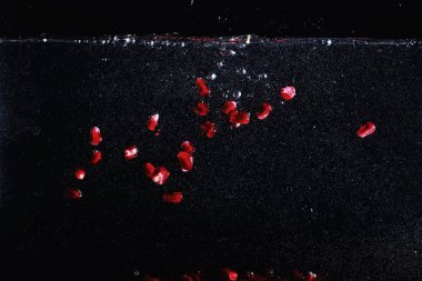 Olgun tatlı nar tohumlarına su damlaları düşer. Metnin için kopyalama alanı olan taze nar arkaplanı. Vejetaryen ve vejetaryen kavramı.