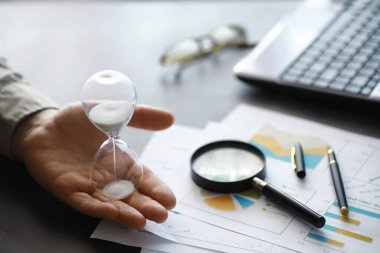 Çalışma zamanı kum saatini sembolize eder. Sigorta müdürü ve bankacı ile ofis masası. Ofis çalışanı masada. Zaman eksikliği kavramı.