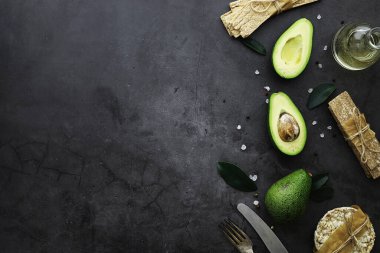 Avokado yemek tarifleri. Tahta kesme tahtasında servis edilen olgun yeşil avokado..