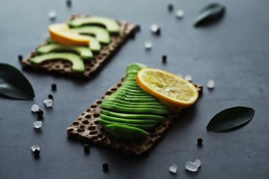 Avokado yemek tarifleri. Tahta kesme tahtasında servis edilen olgun yeşil avokado..