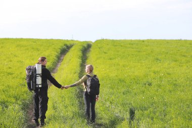 Sırt çantasıyla ve otostopla seyahat ediyor.