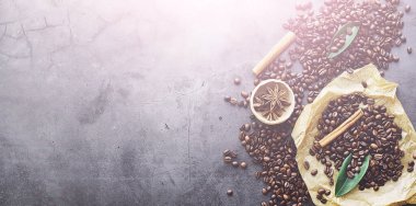 Bir poşet kahve. Kahve çekirdekleri masada kavrulmuş. Pişirmek için yapraklı kahve çekirdekleri.