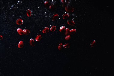 Olgun tatlı nar tohumlarına su damlaları düşer. Metnin için kopyalama alanı olan taze nar arkaplanı. Vejetaryen ve vejetaryen kavramı.