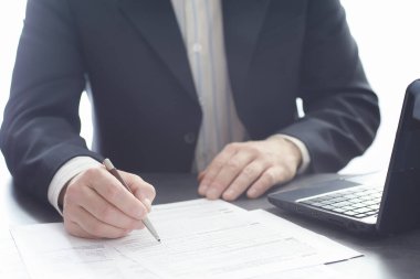 Müdür ofisteki bir dizüstü bilgisayarda çalışıyor. İşadamı çevrimiçi işlem yapıyor. Değiş tokuş internet üzerinden yapılıyor..