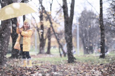 Çocuk parkta ilk karla yürüyor.
