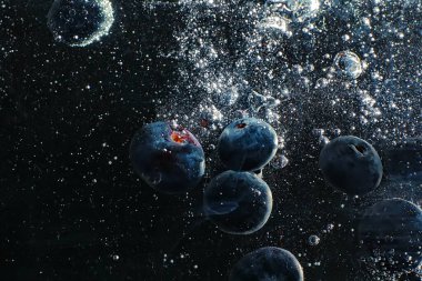 Olgun tatlı yaban mersinine su damlası. Metnin için fotokopi alanı olan taze yabanmersini arkaplanı. Vejetaryen ve vejetaryen kavramı. Yabanmersini dokusunun makro dokusu.