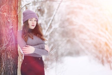 Kış parkında yürüyüş yapan genç bir kız. Kış ormanlarında Noel tatili. Kız parkta kışın tadını çıkarıyor.