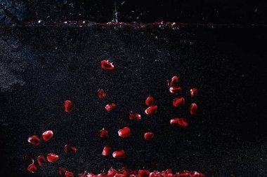 Olgun tatlı nar tohumlarına su damlaları düşer. Metnin için kopyalama alanı olan taze nar arkaplanı. Vejetaryen ve vejetaryen kavramı.