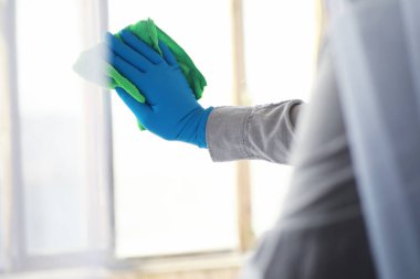 Ev temizliği konsepti. Yüzeylerin tozunu sil. Dezenfektan kapısı TV elektriğini kontrol ediyor. Evdeki karantinada hijyenik tedavi.