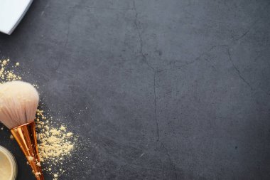 Toz ve makyaj fırçası. Arka planda kahverengi toz. Makyaj ürünleri. Biçim konsepti.