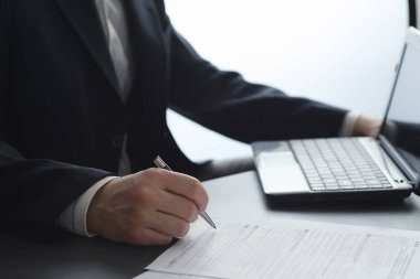 Müdür ofisteki bir dizüstü bilgisayarda çalışıyor. İşadamı çevrimiçi işlem yapıyor. Değiş tokuş internet üzerinden yapılıyor..