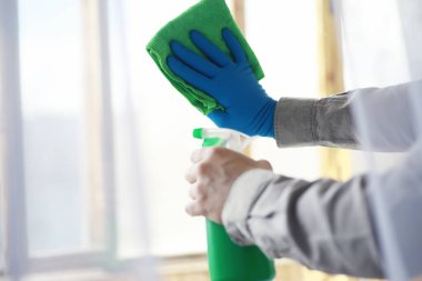 Ev temizliği konsepti. Yüzeylerin tozunu sil. Dezenfektan kapısı TV elektriğini kontrol ediyor. Evdeki karantinada hijyenik tedavi.