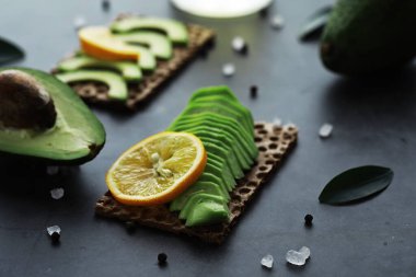 Avokado yemek tarifleri. Tahta kesme tahtasında servis edilen olgun yeşil avokado..