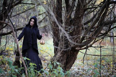 Bir kadın bir ritüel üzerinde yoğun bir orman içinde bir cadı elbiseli