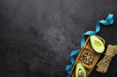 Avokado yemek tarifleri. Tahta kesme tahtasında servis edilen olgun yeşil avokado..