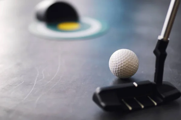 Sport and healthy lifestyle. Mini golf. White golf ball and set minigolf on the table. Sports background with golf concept.