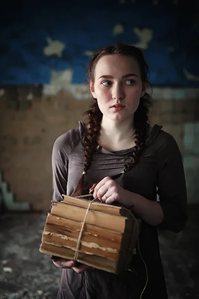 A young girl with old books in the old house