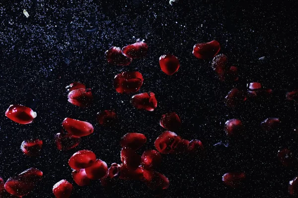 Olgun tatlı nar tohumlarına su damlaları düşer. Metnin için kopyalama alanı olan taze nar arkaplanı. Vejetaryen ve vejetaryen kavramı.