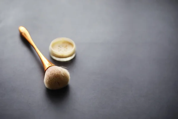 Powder and makeup brush. Brown powder on background. Makeup products. Style concept.