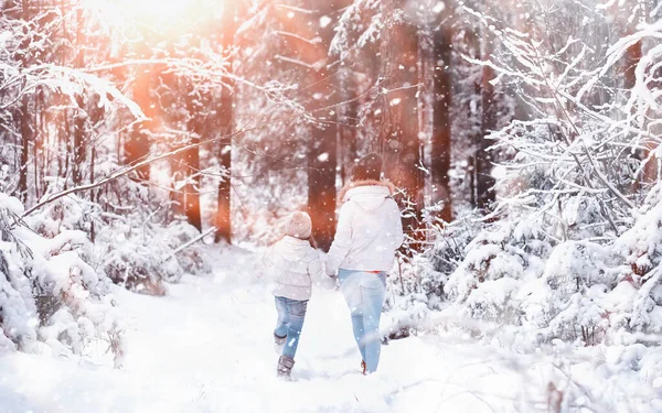 年轻的家庭散步 妈妈和女儿在雪地的公园里散步 — 图库照片